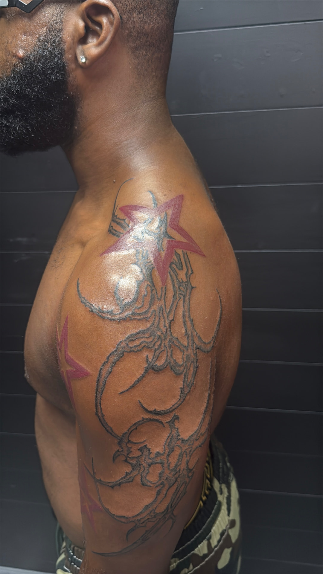 Tribal and red stars shoulder and arm tattoo
